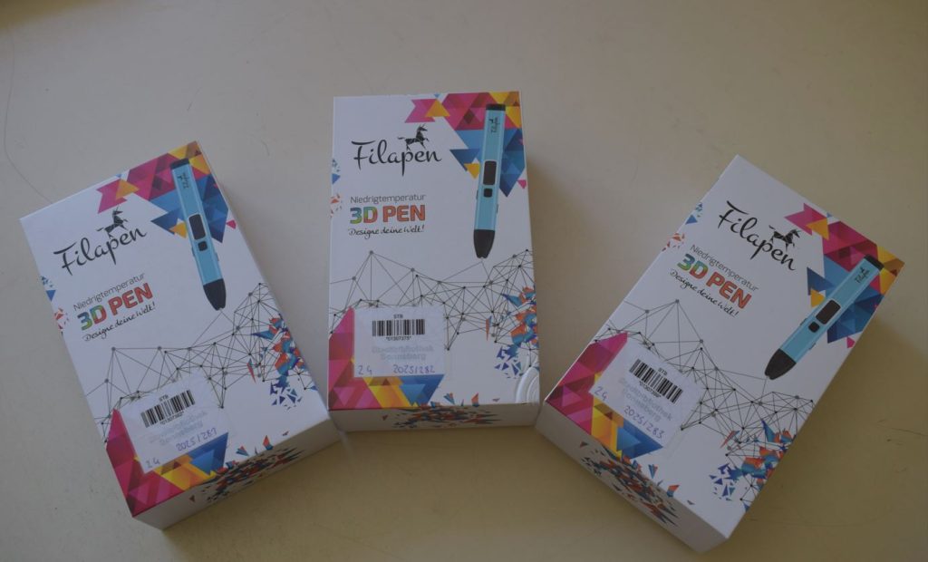 Auf den Bild befinden sich drei Verpackungen von 3D-Druckstiften auf einer Tischplatte.